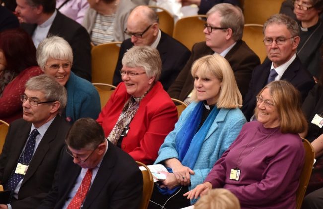 Members of the Church of England's Synod react after a vote to formalize the approval of consecrating women as bishops in central London Monday. The Church of England's governing body on Monday adopted a historic measure allowing women to become bishops. Leon Neal/AFP/Getty Images