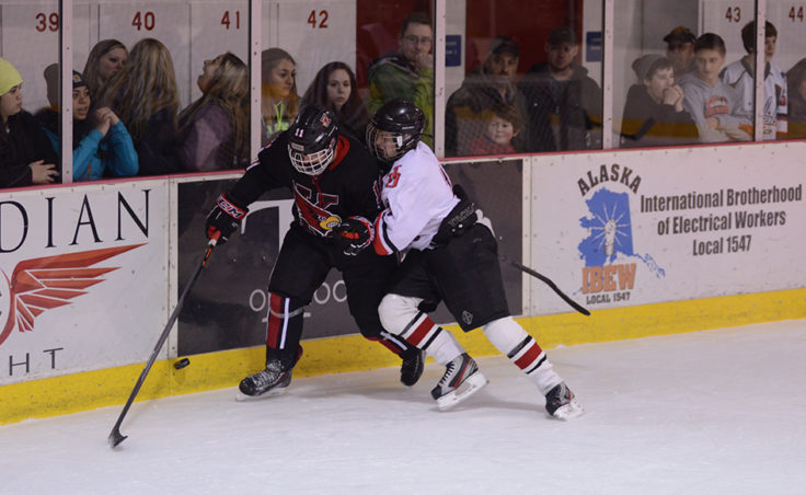 Juneau freshman Jacob Dale knocks Kenai Riley Weber off the puck during Friday night’s contest.
