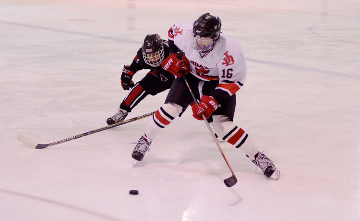 Juneau’s Casey Watts fends off Kenai Ian Mercedo during Saturday’s game at Treadwell Ice Arena.