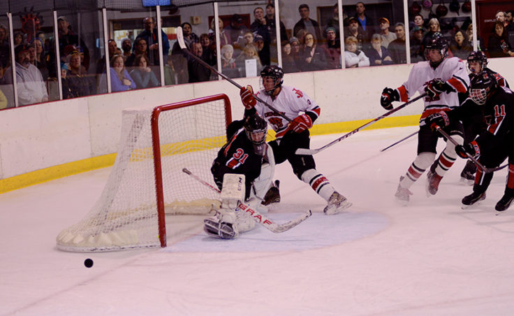 Juneau’s Logan Moser crashes the net with teammate Oscar Jones trailing but can’t get the puck past goalie Nate O’Lena.
