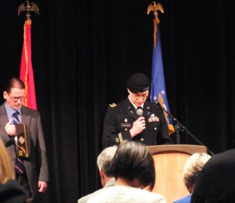 Chaplain Kirk Thorsteinson delivers the invocation as Cmdr. Dan McCrummen of VFW Post 5559 listens during Veterans Day observances at Centennial Hall on Nov. 11, 2014. (Photo by Matt Miller/KTOO)