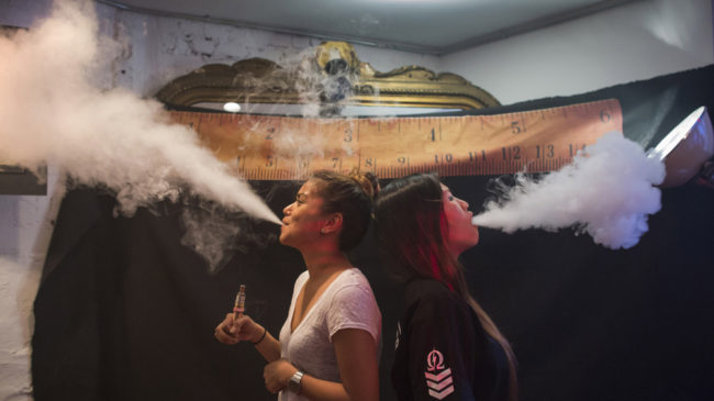 Vape was chosen as the word of the year for 2014 in part because it provides a window "onto how we define ourselves," says Casper Grathwohl of the Oxford University Press. Here, women exhale vapor clouds during a competition at the Henley Vaporium in Manhattan. Elizabeth Shafiroff/Reuters /Landov