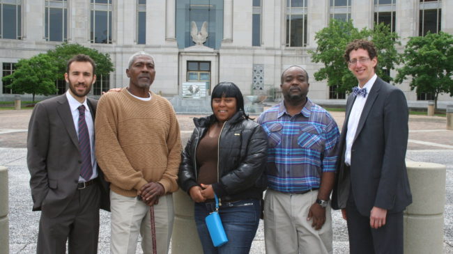 Sharnalle Mitchell (center) in Montgomery in May, after winning an injunction to stop the city from collecting court fines. With her (from left): attorney Alec Karakatsanis, fellow plaintiffs Lorenzo Brown and Tito Williams and attorney Matt Swerdlin. Courtesy of Alec Karakatsanis