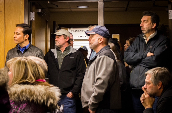 Business owners, nonprofit workers, and residents (including Rep. Neal Foster, left) made for a full house in Nome City Council chambers Monday as the council debated contentious tax issues. (Matthew F. Smith/KNOM)