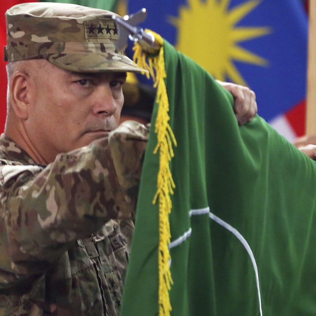 Commander of the International Security Assistance Force (ISAF), Gen. John Campbell opens the "Resolute Support" flag during a ceremony at the ISAF headquarters in Kabul on Sunday. Massoud Hossaini/AP