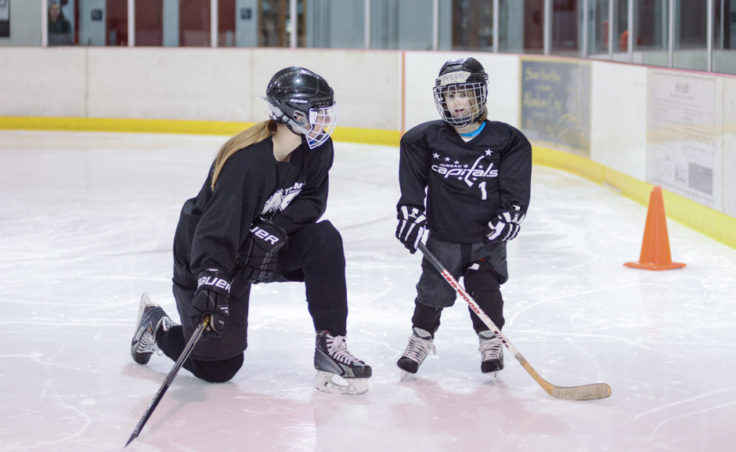 Emma Kaelke chats with Aylin Wolter while waiting their turn to complete a drill during an all-girls hockey clinic Tuesday night at Treadwell Ice Arena.