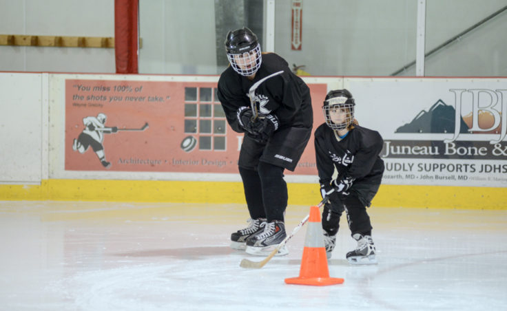Emma Kaelke works with Aylin Wolter on a passing drill during all-girls clinic at Treadwell Ice Arena.