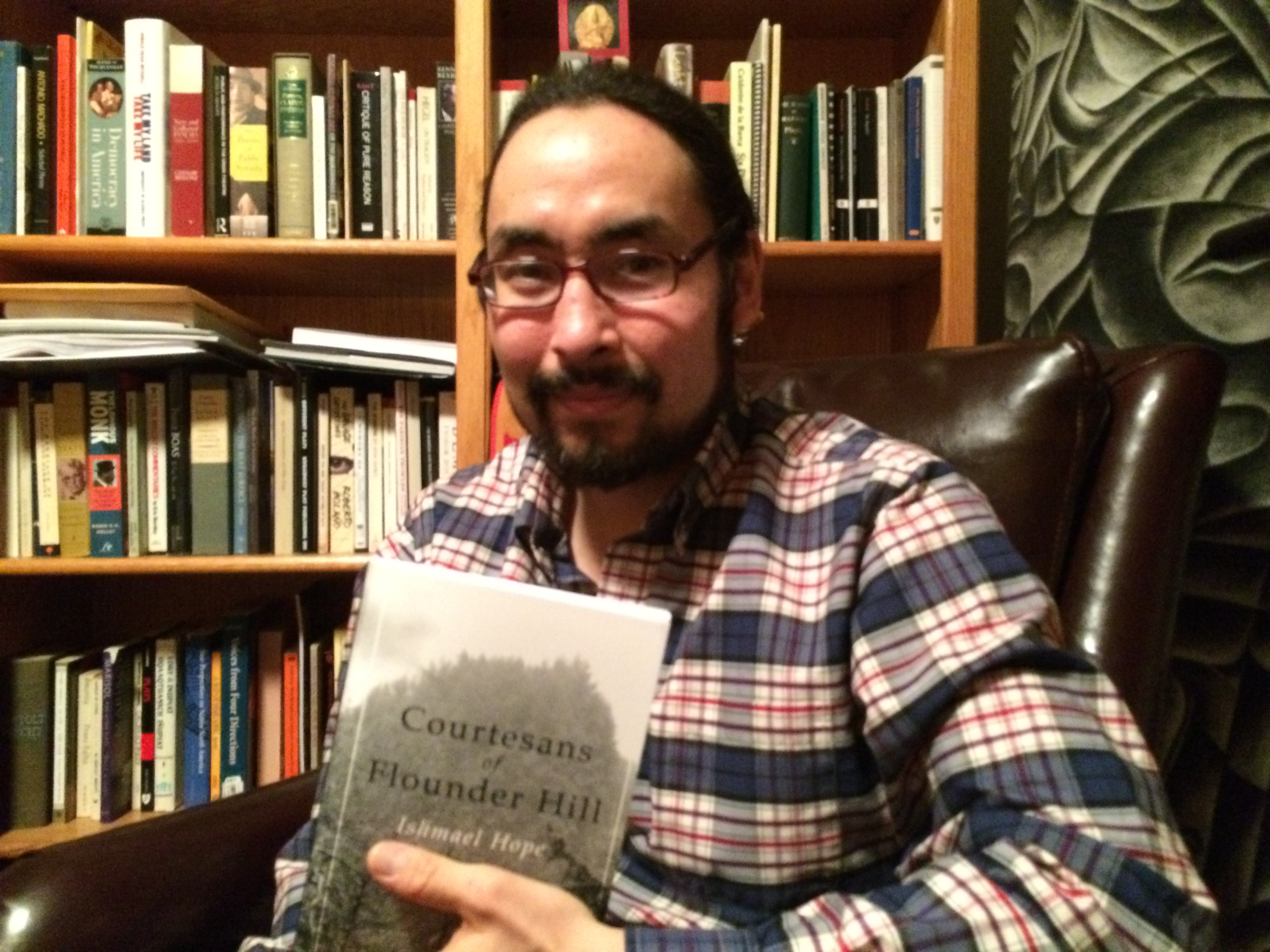 Tlingit and Iñupiaq poet Ishmael Hope with his first collection of poetry "The Courtesans of Flounder Hill". (Photo by Scott Burton/KTOO)