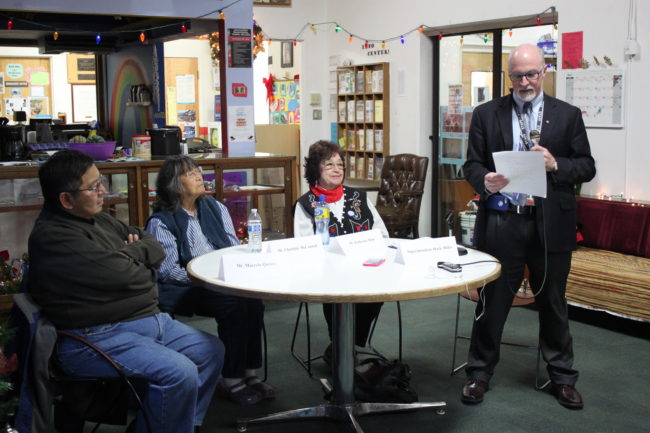 Juneau Schools Superintendent Mark Miller reads his decision in the company of three guests - Marcelo Quinto, Charlotte McConnell and Katherine Hope - who attended Native boarding schools as children. (Photo by Lisa Phu/KTOO)