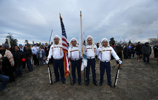 Members of an honor guard from the Arapaho and Cheyenne Native American tribes participate in a sunrise gathering marking the 150th year since the Sand Creek Massacre, at Riverside Cemetery in Denver. Brennan Linsley/AP