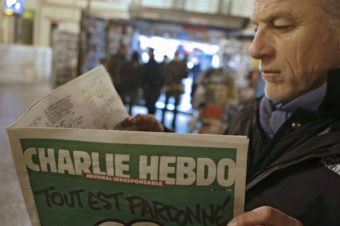 Jean Paul Bierlein reads the latest issue of Charlie Hebdo outside a newsstand in Nice, southeastern France, on Wednesday. Lionel Cironneau/AP