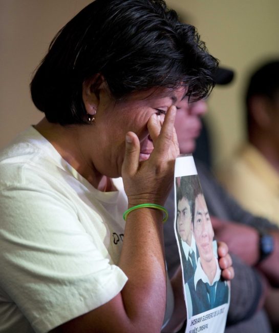 A relative holding a picture of one of the missing students, wipes a tear from her face during a press conference in Mexico, City. Eduardo Verdugo/AP 