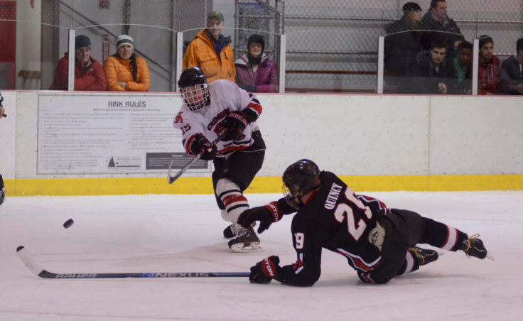 Juneau’s Cole Cheeseman unleashes a shot past a sprawling Houston player Kyle Quincy in the first of two games versus Houston. Cheeseman scored five goals between both games.