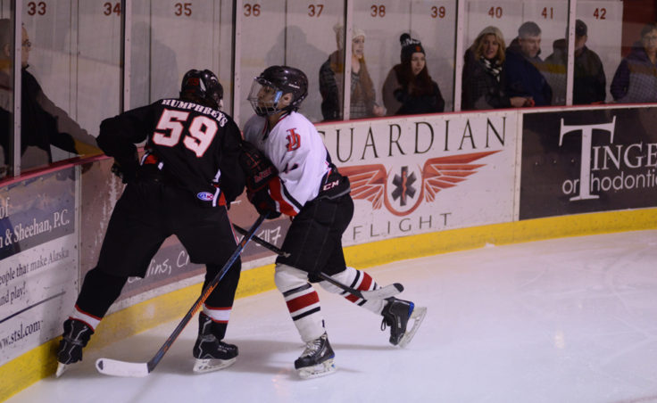 Juneau’s Chase Barnum sizes up Houston’s Reed Humphries in Friday’s game at Treadwell Ice Arena.