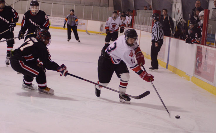 Juneau’s Jacob Dale eludes Houston’s Bradley Fortin in Friday night’s game at Treadwell Ice Arena.