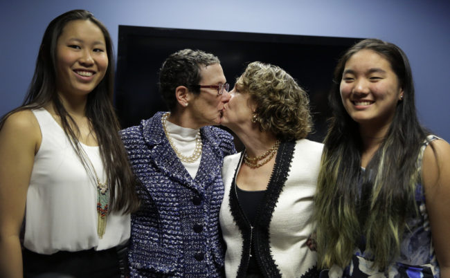 Sarah Goodfriend (left center) and Suzanne Bryant share a kiss Thursday as they pose with their daughters, Dawn Goodfriend (left) and Ting Goodfriend following a news conference in Austin. Eric Gay/AP