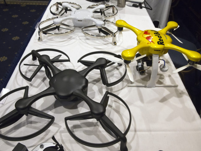 Drones are displayed at an event with the Small Unmanned Aerial Vehicles (UAV) Coalition, last month. The FAA's proposed new rules for their commercial use require certified pilots to fly them and limit their speed, altitude and area of operation. Jacquelyn Martin/AP