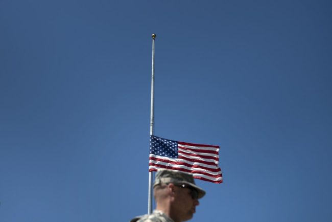 A soldier walks past a flag at half staff before a memorial service at Fort Hood on April 9, 2014 in Texas. Brendan Smialowski /AFP/Getty Images