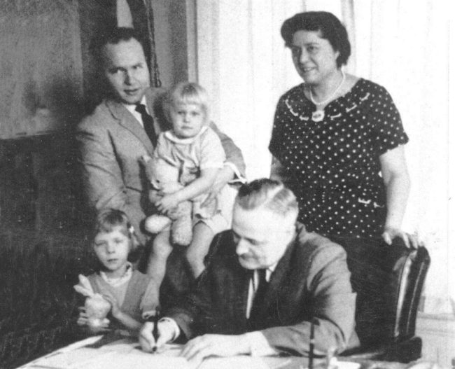 Gov. Bill Egan signs a bill by Rep. Jay Kerttula, holding his daughter Anna, into law. Also pictured, wife  Joyce Kerttula and daughter Beth Kerttula. 