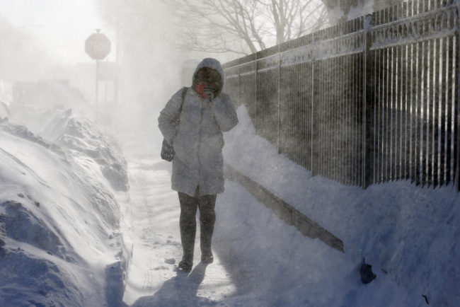 A woman walks through blowing snow in East Boston. New England remained bitterly cold Monday after the region's fourth winter storm in a month blew through. Michael Dwyer/AP