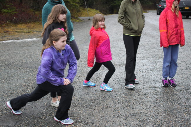 Fifth grader Dani Witt (left) stretches before running. This is her third year doing Girls on the Run. (Photo by Lisa Phu/KTOO)