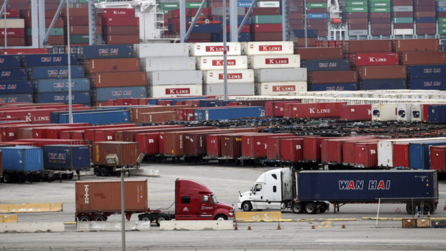 Trucks move containers at the Port of Long Beach, on Tuesday, in Long Beach, Calif. Contract negotiations between dockworkers and shipping companies have led to a slowdown on the piers. Jae C. Hong/AP