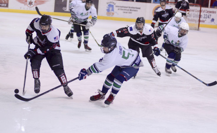 Juneau’s Dalton Hoy advances the puck along the boards in a Friday night game versus Palmer. (Photo by Steve Quinn)