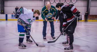 Alaska Governor Bill Walker joined the Juneau and Palmer teams for a ceremonial puck drop. Many governors participate in similar face offs, but Walker likes to lace up his own skates and hit the ice. Taking the face off are Palmer’s Nathan Appell and Juneau’s Joseph Monsef. (Photo by Steve Quinn)