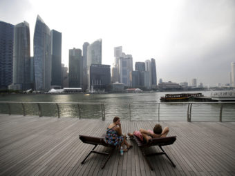 A couple enjoys the view of Singapore's financial center. Conservatives saw Singapore as a free-market success story, but Lee Kuan Yew's government played a big role in the economy. (Photo by Wong Maye-E/AP)