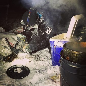 Temperatures of more than 30 below didn’t stop Dallas Seavey from mixing up a concoction of fat, meat and kibble for his team after they reached Kaltag. (Photo by Emily Schwing/APRN)