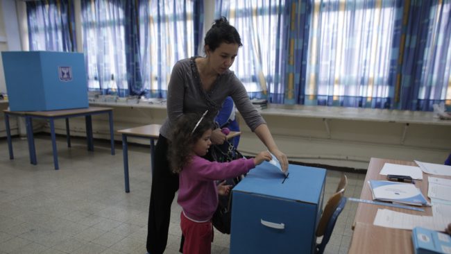 An Israeli woman votes with her daughter at a polling station in the coastal city of Haifa on Tuesday. Israel faces an unpredictable election to determine whether Prime Minister Benjamin Netanyahu will remain in power. Ahmad Gharabli /AFP/Getty Images