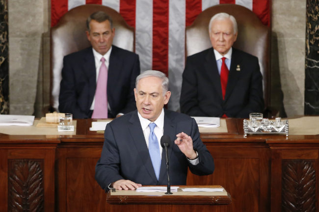 Israeli Prime Minister Benjamin Netanyahu speaks before a joint meeting of Congress on Capitol Hill in Washington on Tuesday. Netanyahu said the world must unite to "stop Iran's march of conquest, subjugation and terror." House Speaker John Boehner of Ohio (left) and Sen. Orrin Hatch, R-Utah, listen. Andrew Harnik/AP