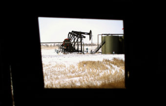 A production site in the Bakken oil patch as seen from inside an abandoned farmhouse just outside Watford City, N.D. (Photo by David Gilkey/NPR)