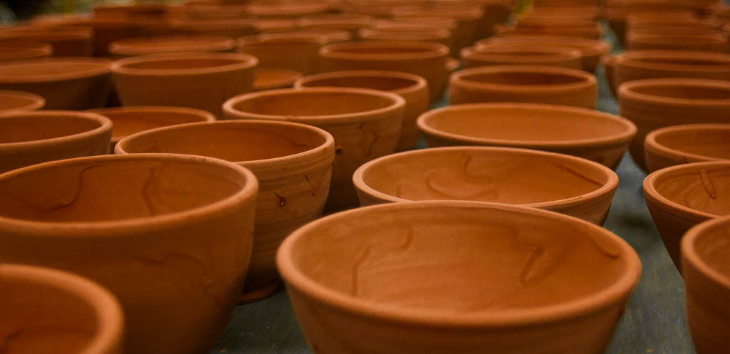 Dozens of clay bowls at The Canvas just finished being glazed and waiting for final firing (Photo by David Purdy/KTOO)
