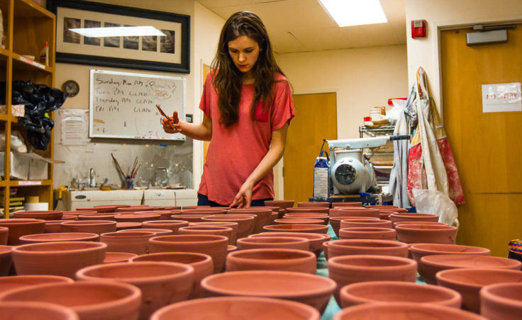 Mercedes Muñoz with the bowls she has just finished glazing for the Empty Bowls fundraiser (Photo by David Purdy/KTOO)