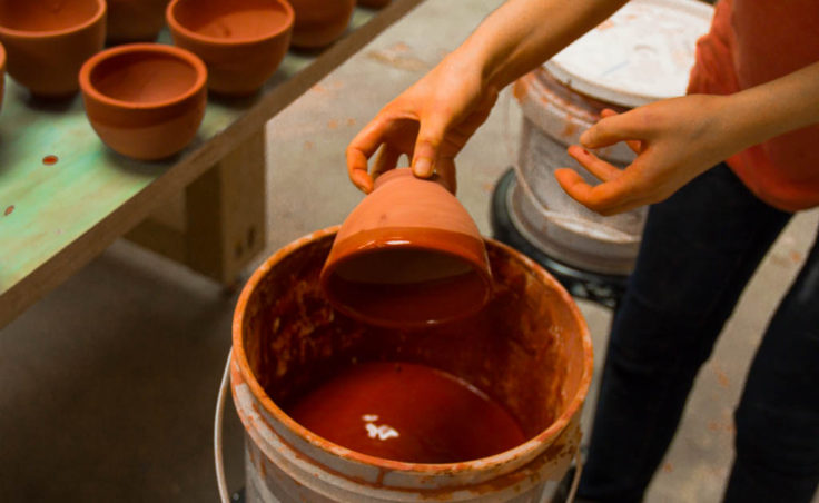 Mercedes Muñoz demonstrates dipping the rim of a bowl (Photo by David Purdy/KTOO)