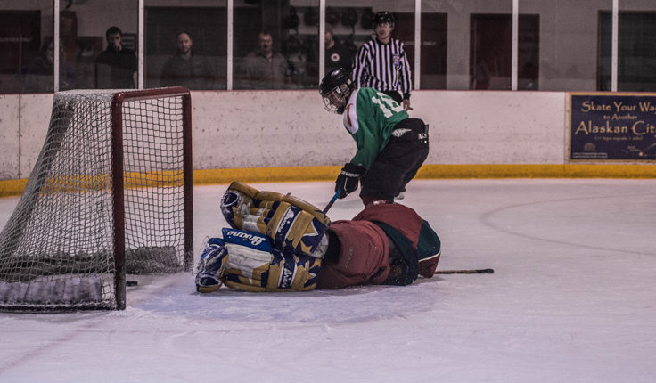 Good Hardware’s Tom McKenna slips the puck past an outstretched goalie Brad Robbins of Svensson Boatworks during a shootout to determine the winner. (Photo by Steve Quinn)