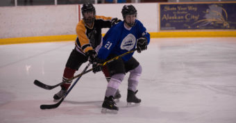 Rendezvous’ Jason Bluhm and Bleau Chunks Nate Haddock battle for position in playoff action during a Juneau Adult Hockey Association contest. (Photo by Steve Quinn)