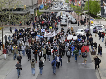 Earlier this week, protesters marched for Freddie Gray through downtown Baltimore. Gray died from spinal injuries about a week after he was arrested and transported in a police van. A larger protest is planned for Saturday afternoon. (Photo by Patrick Semansky/AP)
