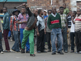 South African hostel dwellers demonstrate against foreigners in Johannesburg on Friday after overnight violence between locals and immigrants in the city. (Photo by Shiraaz Mohamed/AP)