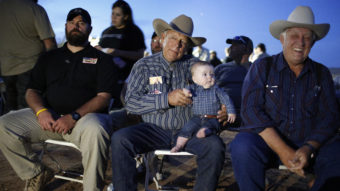 Rancher Cliven Bundy holds his 5-month-old grandson Roper Cox on Saturday in Bunkerville, Nev. Bundy was hosting an event to mark one year since the Bureau of Land Management's failed attempt to collect his cattle. (Photo by John Locher/AP)
