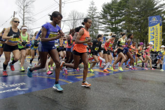 Runners cross the start line in the women's division of Boston Marathon on Monday in Hopkinton, Mass. (Photo by Stephan Savoia/AP)