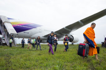 Monks and aid workers walk to the arrival terminal at Kathmandu's international airport. The plane was unable to secure an arrival gate when it landed on April 29. (Photo by Taylor Weidman/LightRocket/Getty Images)