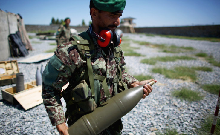 A soldier carries a shell to a Soviet-era artillery gun. Afghan officers say the Taliban not only cross the border, they hide in the villages, dropping their weapons and picking up a shovel when the soldiers appear. (Photo by David Gilkey/NPR)