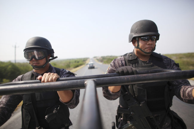 State police officers patrol a highway between Ciudad Victoria and Matamoros, in northeast Mexico, in 2011. Mexico's drug and turf wars have descended on the once tourist friendly border town of Matamoros. Alexandre Meneghini/AP