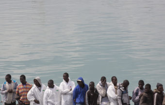 Migrants wait to disembark at the Catania harbor in southern Italy on April 24. In recent weeks, hundreds of migrants leaving Libya have drowned trying to cross the Mediterranean Sea to European countries, including Italy, Spain and Greece. (Photo by Alessandra Tarantino/AP)