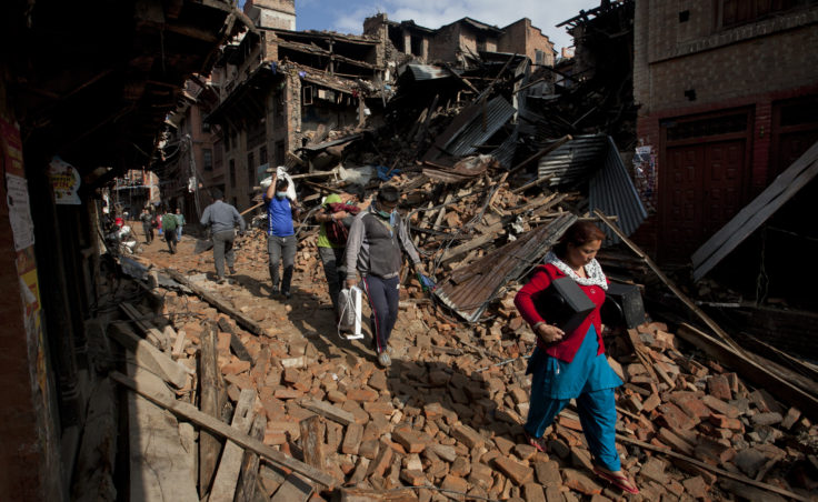 Nepalese residents carry belongings from their destroyed homes