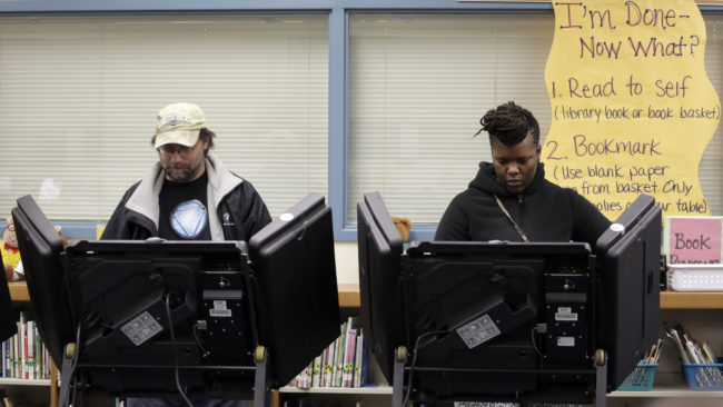 Rich Baranowski (left) and Tracy Hardy vote Tuesday in the Ferguson, Mo., municipal election. Three of the city's six seats will now be filled by black council members. (Photo by Jeff Roberson/AP)
