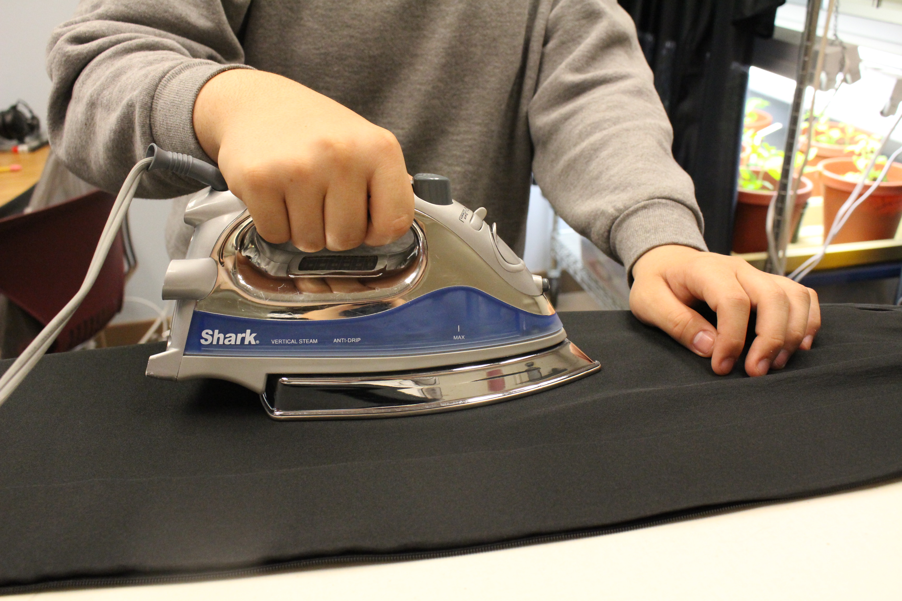 A JYC resident irons their gown for graduation. (photo by Elizabeth Jenkins/KTOO)