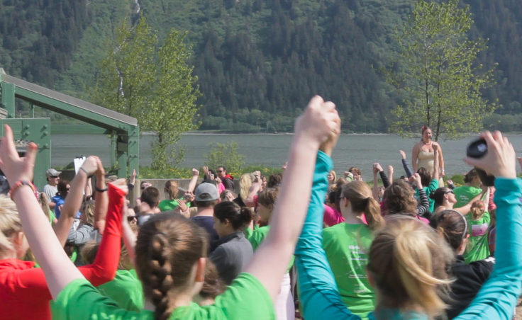 Runners join in warm-ups and cheers before the run (Photo by David Purdy/KTOO)